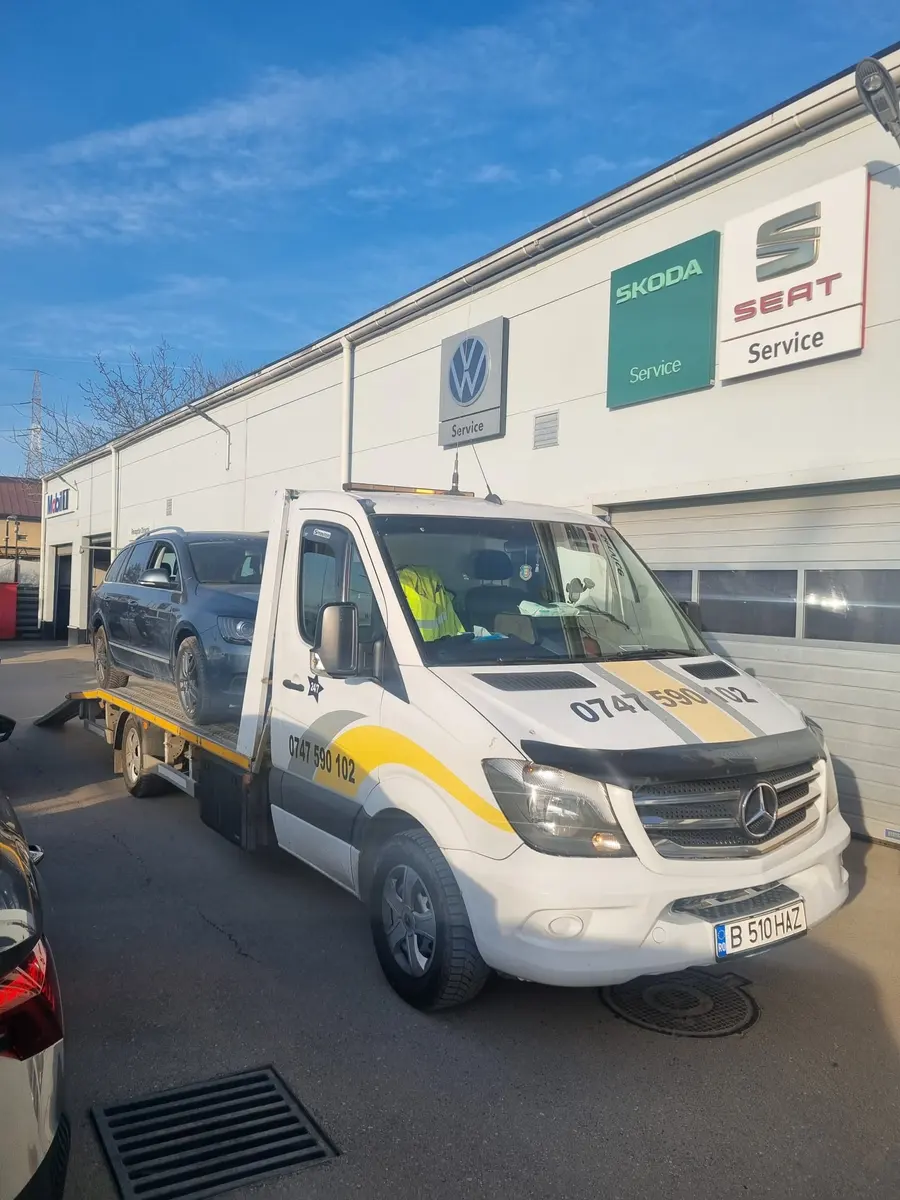 Vedere frontală a platformei albe, cu telefonul 0747 590 102 pe capotă